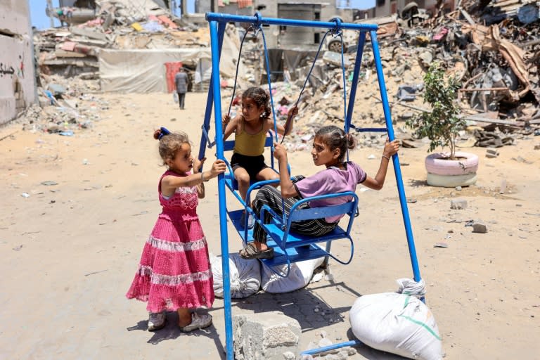 Unas niñas juegan en un balancín en el campo de refugiados palestino de Jabalia, el 17 de junio de 2024 al norte de la Franja de Gaza (Omar al Qattaa)