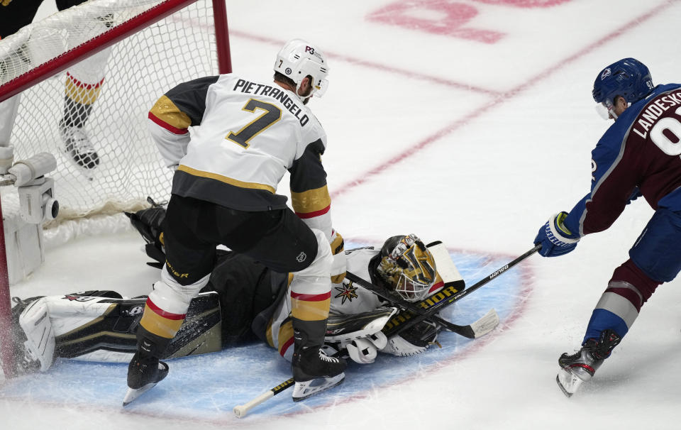 Colorado Avalanche left wing Gabriel Landeskog, right, has his shot stopped by Vegas Golden Knights goalie Robin Lehner, back left, as defenseman Alex Pietrangelo looks on in the first period of an NHL hockey game Tuesday, Oct. 26, 2021, in Denver. (AP Photo/David Zalubowski)