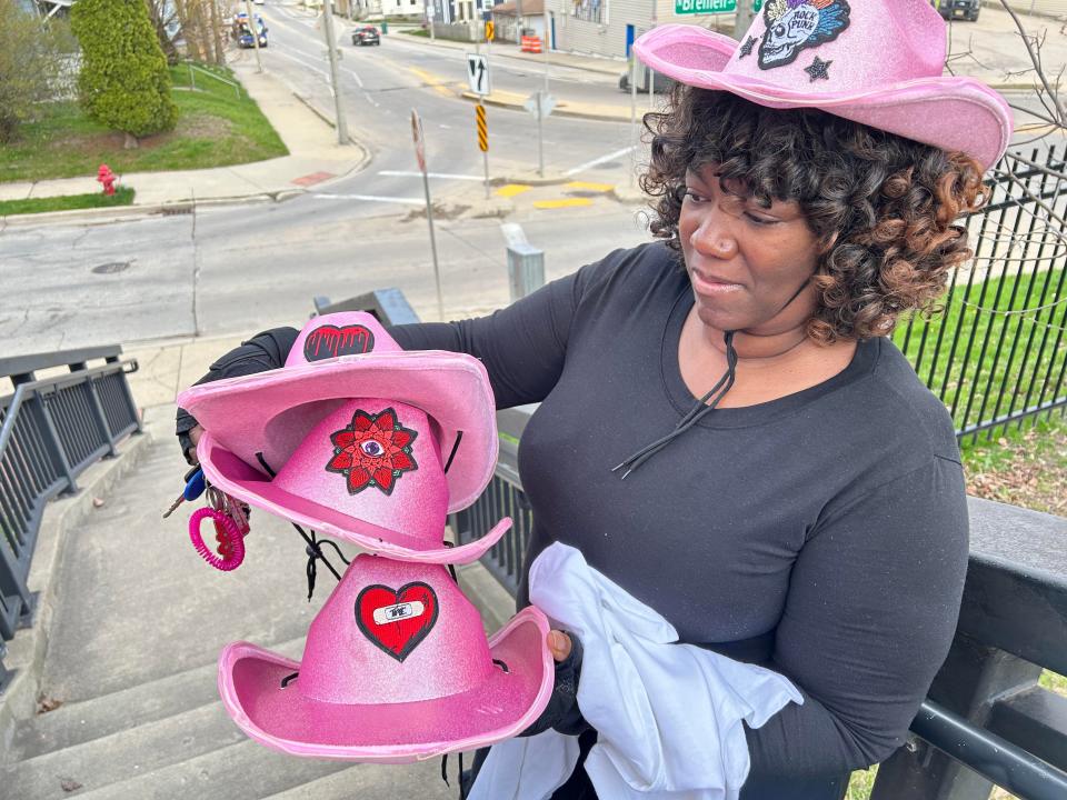 Tawana Harris of Milwaukee brought pink cowboy hats to a Friday night vigil for Sade Robinson. Harris worked with Robinson at Pizza Shuttle and described her as her "spiritual daughter."