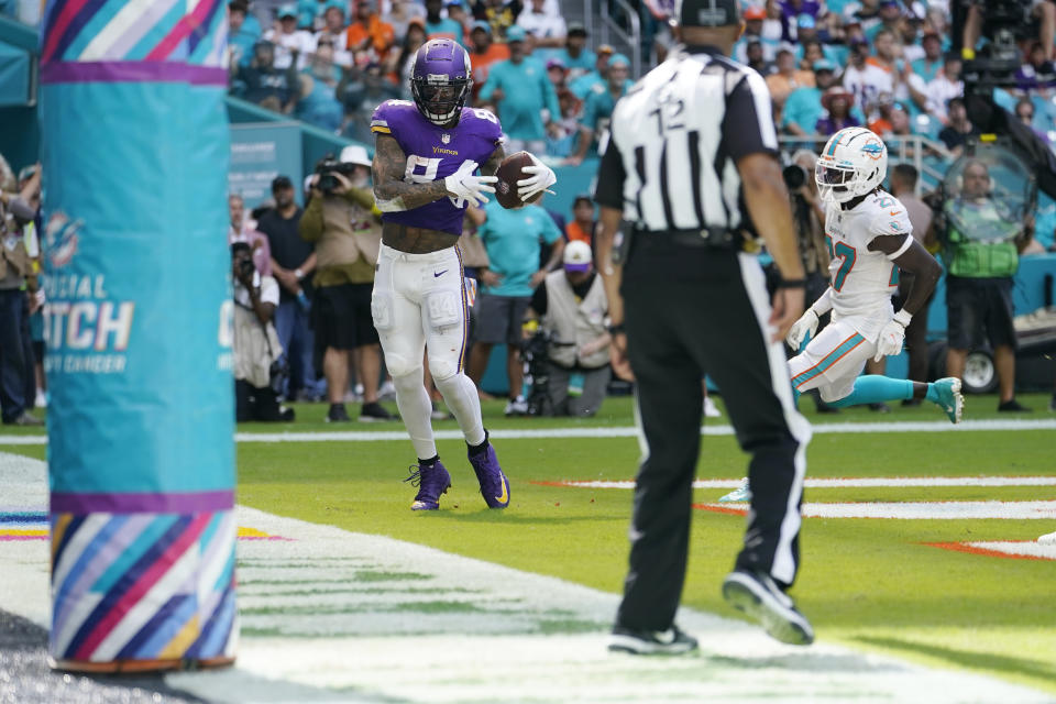 Minnesota Vikings tight end Irv Smith Jr. (84) makes a catch for a touchdown, pursued by Miami Dolphins cornerback Keion Crossen (27), during the first half of an NFL football game, Sunday, Oct. 16, 2022, in Miami Gardens, Fla. (AP Photo/Lynne Sladky)