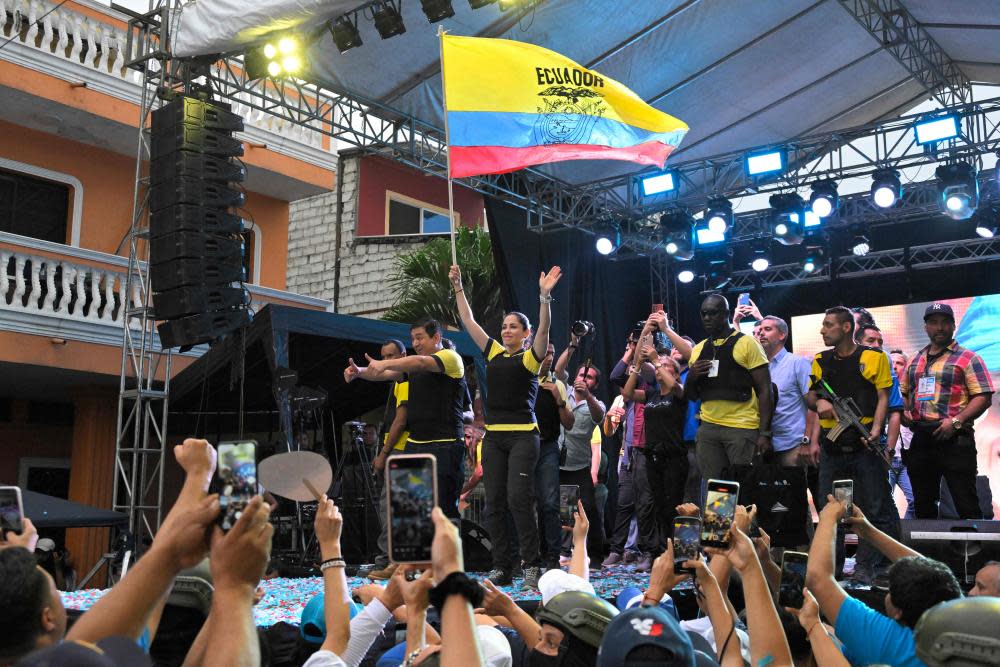 people wearing bullet proof vests on a stage waving flags