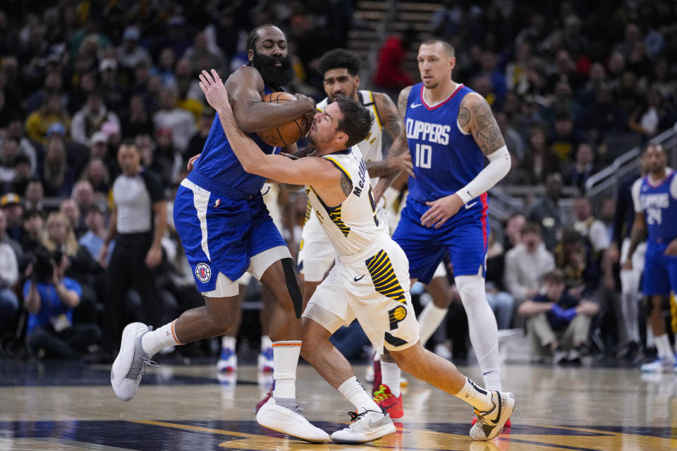 Indiana Pacers guard T.J. McConnell (9) gets tied up with Los Angeles Clippers guard James Harden (1) during the first half of an NBA basketball game in Indianapolis, Monday, Dec. 18, 2023. (AP Photo/Michael Conroy)