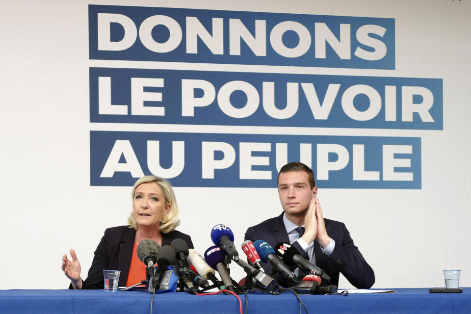 French far-right leader Marine Le Pen, left, and top of the list Jordan Bardella attend a press conference in Henin-Beaumont, northern France, Friday, May. 24, 2019. Polls suggest that Le Pen's party will be among France's top two vote-getters in the election, along with French President Emmanuel Macron's party. Poster behind reads: Give the power to the People. (AP Photo/Michel Spingler)