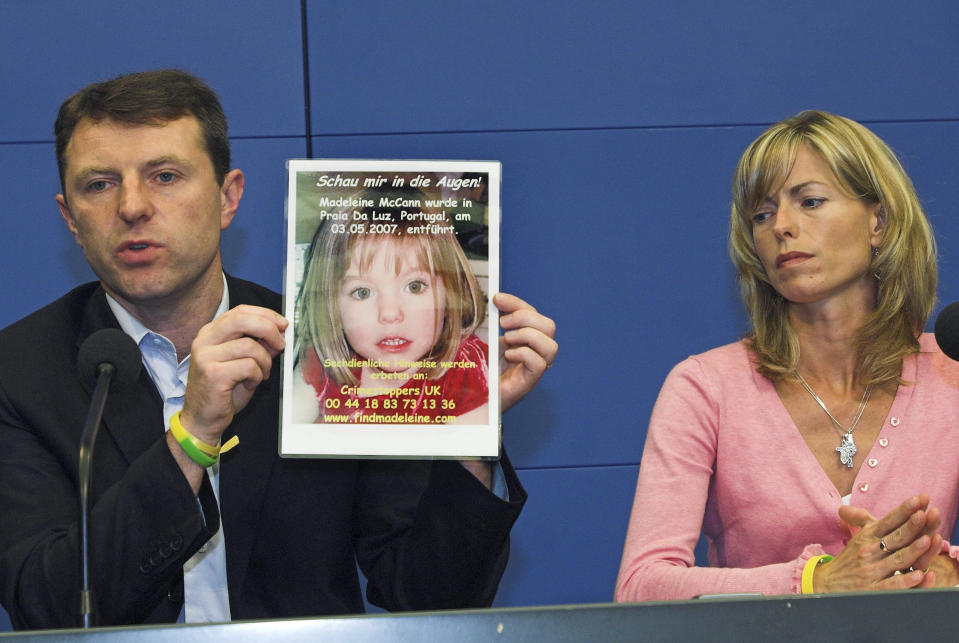 FILE - Gerry, left, and Kate McCann, parents of four-year old Madeleine McCann, missing from the Portuguese town of Praia Da Luz since May, present a picture of their daughter during a press conference in Berlin, Wednesday, June 6, 2007. A man who is also a suspect in the disappearance of British toddler Madeleine McCann goes on trial Friday over several sexual offenses he is alleged to have committed in Portugal between 2000 and 2017. (AP Photo/Sven Kaestner, File)