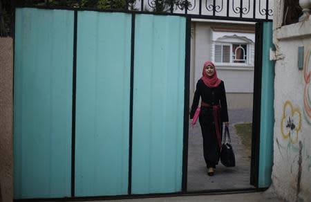 Isra Al-Modallal, a spokeswoman of the Hamas government in Gaza, leaves her house as she heads to the office, at Rafah refugee camp in the southern Gaza Strip November 10, 2013. REUTERS/Ibraheem Abu Mustafa
