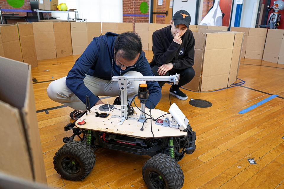 Rahul Menan, a first-year master's student, left, and Sarah Etter, a first-year doctoral student, troubleshoot an issue with a robot called Alpha Truck at a Texas Robotics lab in the University of Texas Anna Hiss Gymnasium.