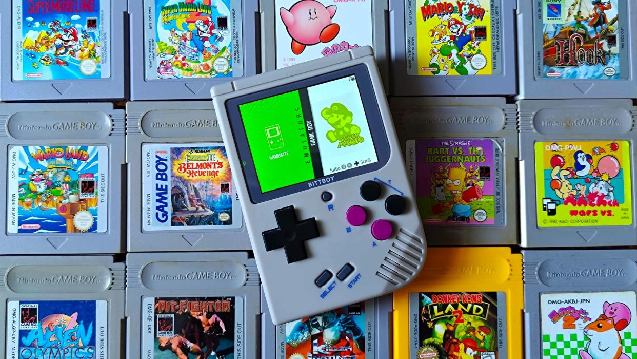  Bittboy retro handheld on top of old Game Boy cartridges . 