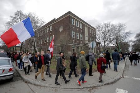 Two men carry the French and Canadian flags as French citizens line up to cast their vote for Sunday's French presidential election at the Collège Stanislas in Montreal, Quebec, Canada, April 22, 2017. REUTERS/Dario Ayala