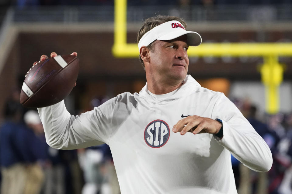 Mississippi coach Lane Kiffin passes the ball to a player during warmups for the team's NCAA college football game against Mississippi State in Oxford, Miss., Thursday, Nov. 24, 2022. (AP Photo/Rogelio V. Solis)