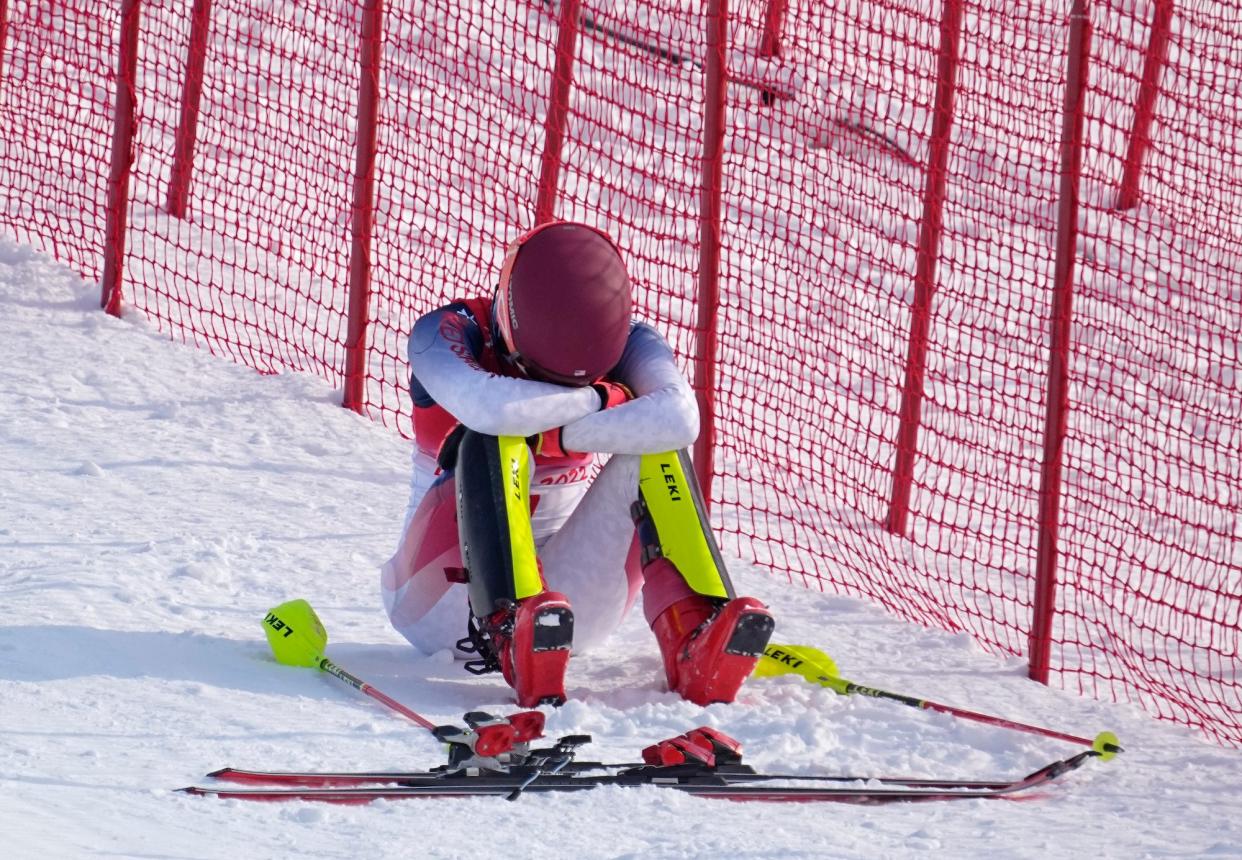 Mikaela Shiffrin sits with her head in her hands after falling in the slalom at the Olympics.