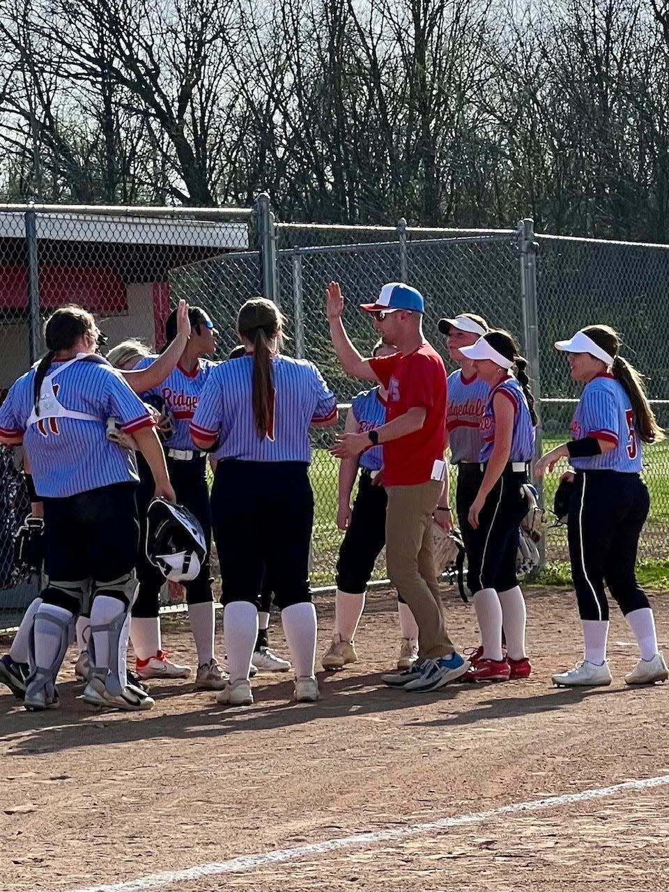 New Ridgedale softball coach Austin Riegel meets with his team between innings of a home game with North Baltimore this season.