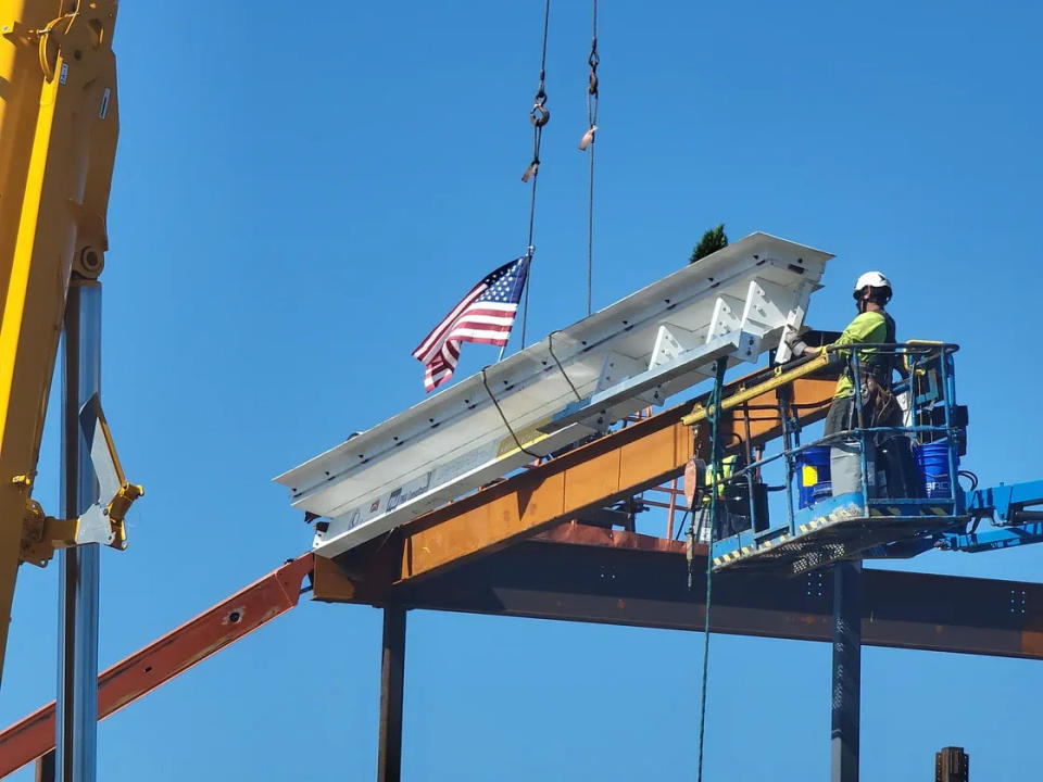 An ironworker guides into place the ceremonial final beam of the new Bristol-Plymouth Regional Technical School in Taunton on Friday, May 31, 2024.