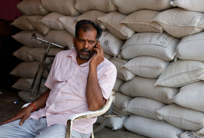 Sanjay Kumar speaks on his mobile phone at a wholesale grain market in Mathura