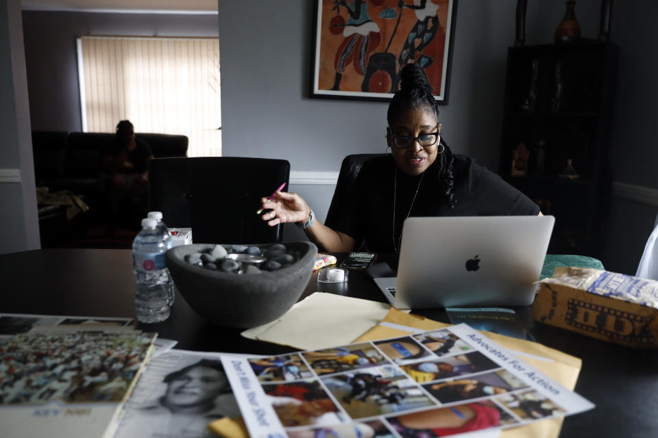 Kimberly Ross-Holmes works on her laptop at her home in Evanston, Friday, April 23, 2021. The Chicago suburb will become the first to pay reparations in the form of housing grants. She said she is glad that Juneteenth will be a federal holiday, but hopes that the federal government takes up more issues that affect the everyday lives of Black people. (AP Photo/Shafkat Anowar)