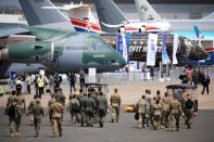 Soldiers walk past aircrafts on static display, at the eve of the opening of the 53rd International Paris Air Show at Le Bourget Airport near Paris