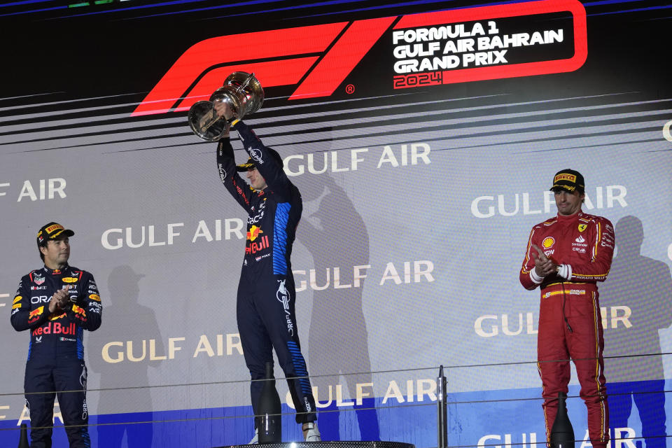 First place, Red Bull driver Max Verstappen of the Netherlands, center, holds his trophy as he stands on the podium with second place, Red Bull driver Sergio Perez of Mexico, left, and third place, Ferrari driver Carlos Sainz of Spain during the Formula One Bahrain Grand Prix at the Bahrain International Circuit in Sakhir, Bahrain, Saturday, March 2, 2024. (AP Photo/Darko Bandic)