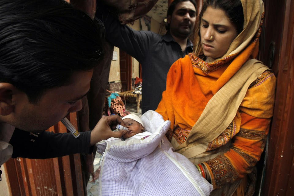 In this Feb. 2, 2014 photo, a Pakistani health worker vaccinates a child against polio, in Peshawar, Pakistan. Pakistan's beleaguered battle to eradicate polio is threatening a global, multi-billion dollar campaign to wipe out the disease worldwide. Because of Pakistan, the virus is spreading to countries that were previously polio-free, U.N. officials say. (AP Photo/Mohammad Sajjad)