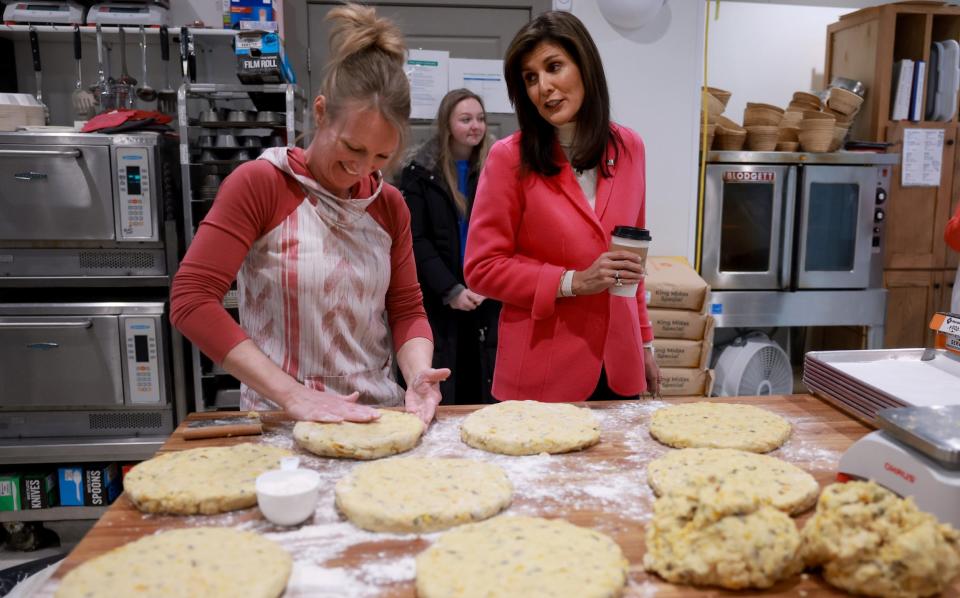 Republican presidential candidate former U.N. Ambassador Nikki Haley interacts with Kim Morgan as she makes scones during a campaign stop at The Bread Board