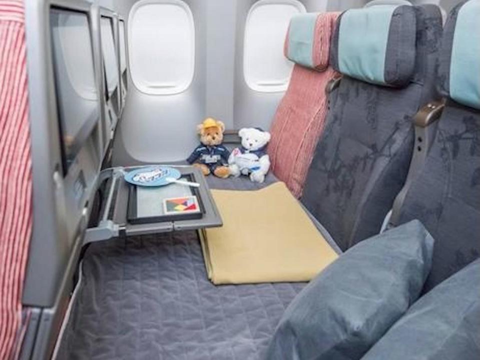A family couch with a blanket and stuffed animals aboard a China Airlines Boeing 777-300ER.