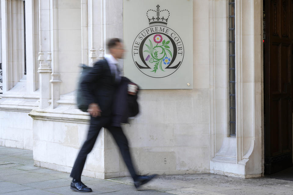 A man walks into the Supreme Court in London, Wednesday, Nov. 15, 2023. Britain's highest court is set to rule Wednesday, Nov. 15 on whether the government's plan to send asylum-seekers to Rwanda is legal, delivering a boost or a blow to a contentious central policy of Prime Minister Rishi Sunak's administration. Five justices on the U.K. Supreme Court will deliver judgment in the government's attempt to overturn a lower court ruling that blocked deportations. (AP Photo/Kirsty Wigglesworth)