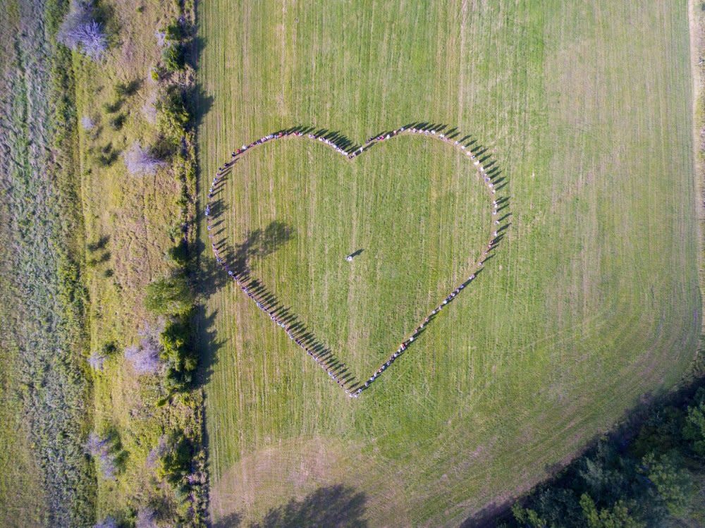 Friends of the bride and groom surround them with a symbol of love. (Photo: Mack Evenden/Evendenimaging.ca)