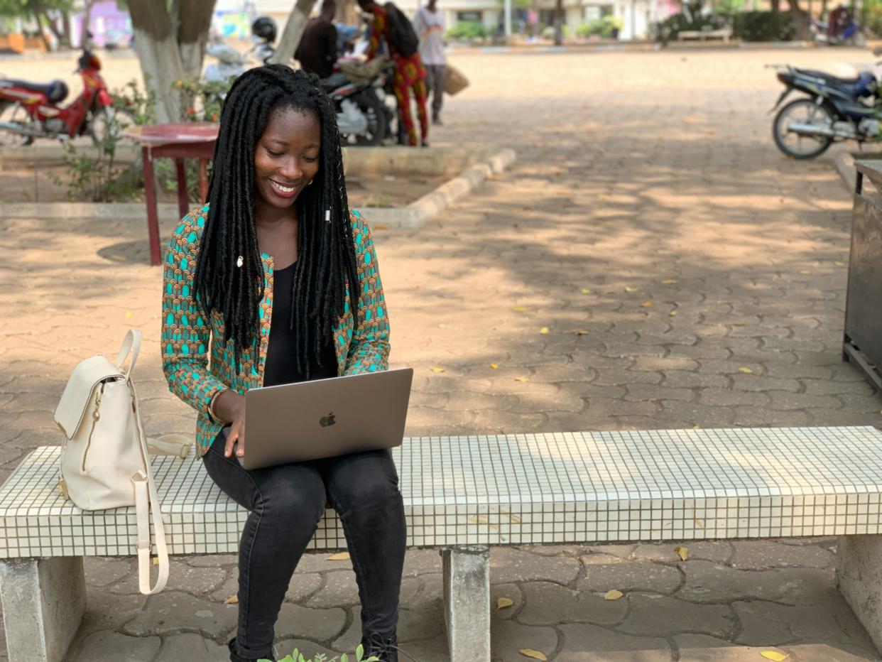 Gen Z Slang pictured: woman smiling at laptop | Photo via Iwaria Inc./Unsplash