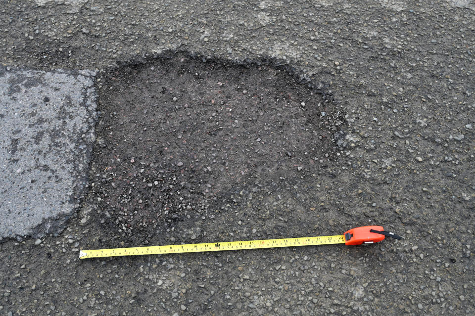 Some of the potholes on Caernarvon Road in Cheltenham measure 50cm in diameter, February 23 2024. See SWNS story SWLNpothole. Residents are baffled after the council could 'only afford' to repair a tiny 230m stretch of their pothole-filled road - leaving most of it full of holes. This week workers visited Caernarvon Road in Cheltenham, Gloucestershire, after weeks of complaints from residents over the state of the road. But they only filled in huge potholes on a small stretch - leaving the remaining 500m filled with 50cm potholes. Residents claim the council told they they only had enough cash in the kitty to fill in the tiny stretch.