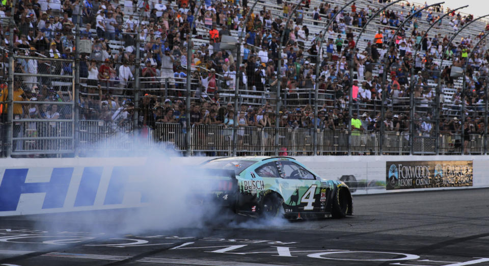 Kevin Harvick smokes his tires for fans after winning a NASCAR Cup Series auto race at New Hampshire Motor Speedway in Loudon, N.H., Sunday, July 21, 2019. (AP Photo/Charles Krupa)