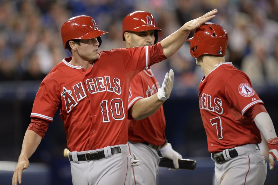 Los Angeles Angels' Albert Pujols, center, congratulates teammates Grant Green, left, and Collin Cowgill after they scored on a Mike Trout double during third inning American League baseball action against the Toronto Blue Jays in Toronto on Monday, May 12, 2014. (AP Photo/The Canadian Press, Frank Gunn)