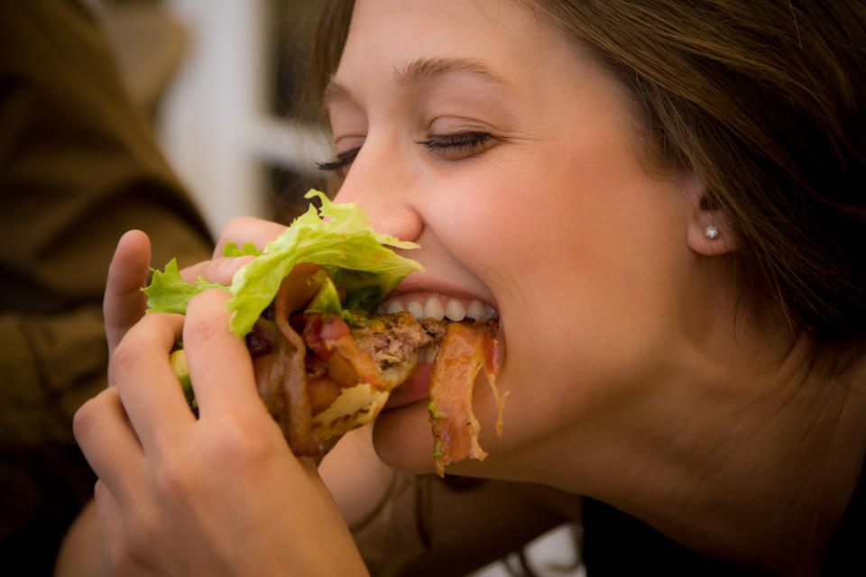 A woman taking a bite of food