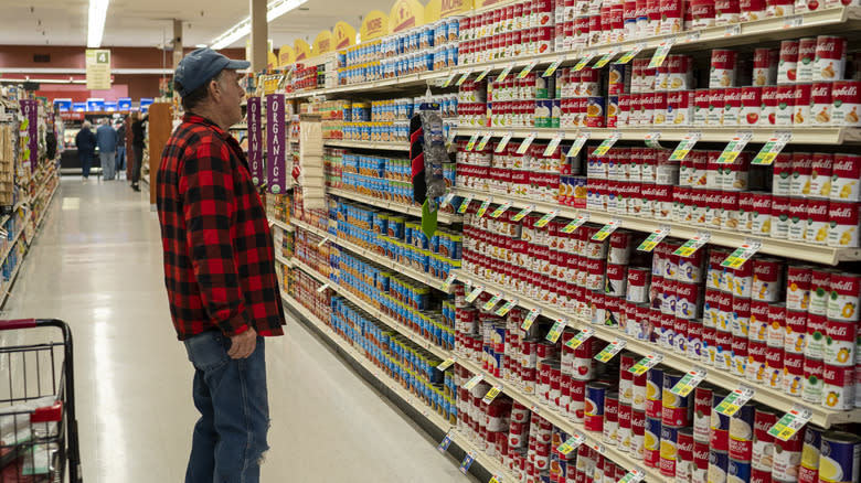 person in canned food aisle