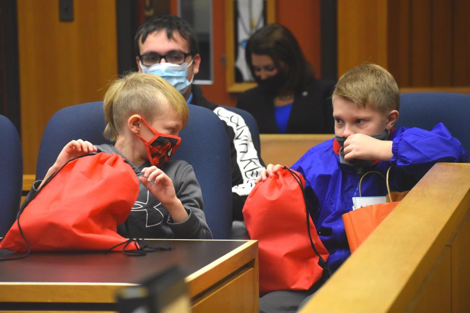 Brantly, 10, right, and Seth, 8, talk to each other Monday, during Lenawee County's Adoption Day ceremony in Lenawee County Probate Judge Catherine A. Sala's courtroom. The brothers were officially adopted by Adrian residents Dennis and Brigitte Sneyd.