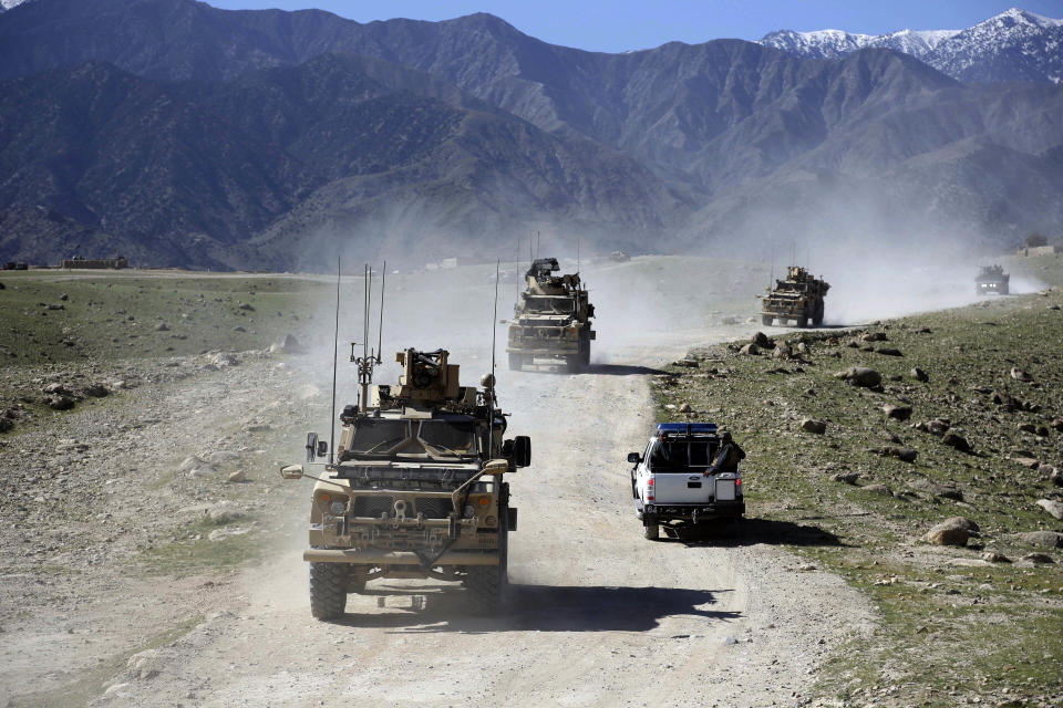 FILE - In this April 2014 file photo, U.S. forces and Afghan commando patrol Pandola village near the site of a U.S. bombing in the Achin district of Jalalabad, east of Kabul, Afghanistan. When he pulled the plug on the American war in Afghanistan, President Joe Biden said the reasons for staying, 10 years after the death of al-Qaida leader Osama bin Laden, had become "increasingly unclear.” Now that the final withdrawal is under way, questions about clarity have shifted to Biden's post-withdrawal plan. (AP Photo/Rahmat Gul, File)