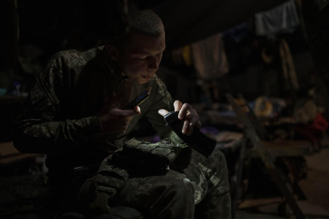 A Ukrainian Border Guard soldier cleans the magazine of his weapon prior to a military exercise in central Ukraine, Monday, May 1, 2023. Ahead of the much-anticipated Ukrainian counter-offensive, newly formed military assault units train in the country's dense forests. (AP Photo/Bernat Armangue)