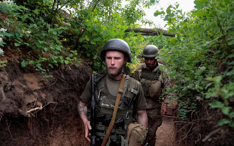 Ukrainian servicemen walk in a trench at a position near a frontline in Donetsk  - SERHII NUZHNENKO /REUTERS
