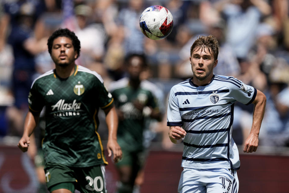 Portland Timbers midfielder Evander (20) and Sporting Kansas City midfielder Jake Davis (17) chase the ball during the first half of an MLS soccer match Sunday, May 28, 2023, in Kansas City, Kan. (AP Photo/Charlie Riedel)