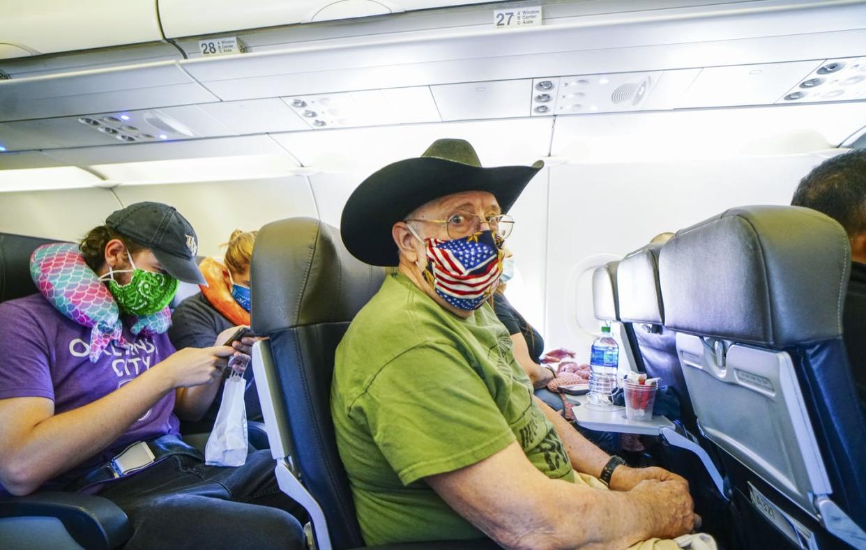 <span class="caption">Passengers onboard an American Airlines flight to Charlotte, North Carolina, from San Diego, California. </span> <span class="attribution"><a class="link " href="https://www.gettyimages.com/detail/news-photo/passengers-onboard-an-american-airlines-flight-to-charlotte-news-photo/1214261343?adppopup=true" rel="nofollow noopener" target="_blank" data-ylk="slk:Sandy Huffaker/Getty Images;elm:context_link;itc:0;sec:content-canvas">Sandy Huffaker/Getty Images</a></span>