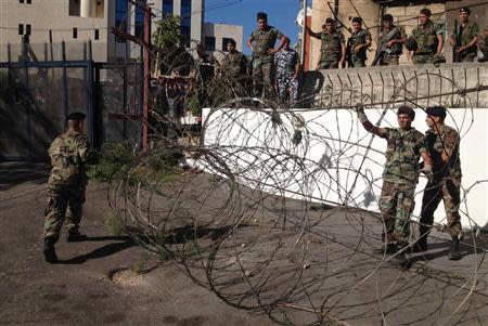 Lebanese army soldiers and policemen secure an area as they close a road leading to the U.S. embassy with barbed wire and barricades, ahead of a protest against potential U.S. strikes on Syria, in Awkar, north of Beirut, September 6, 2013. U.S. officials ordered non-emergency personnel and their family members out of Lebanon on Friday "due to threats," the U.S. embassy in Beirut said in statement. REUTERS/Mohamed Azakir