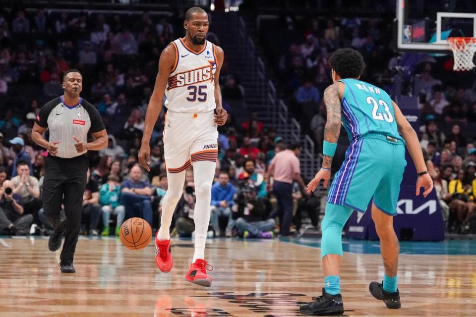 Mar 15, 2024; Charlotte, North Carolina, USA; Phoenix Suns forward Kevin Durant (35) brings the ball up court against Charlotte Hornets guard Tre Mann (23) during the first quarter at Spectrum Center. Jim Dedmon/USA TODAY Sports