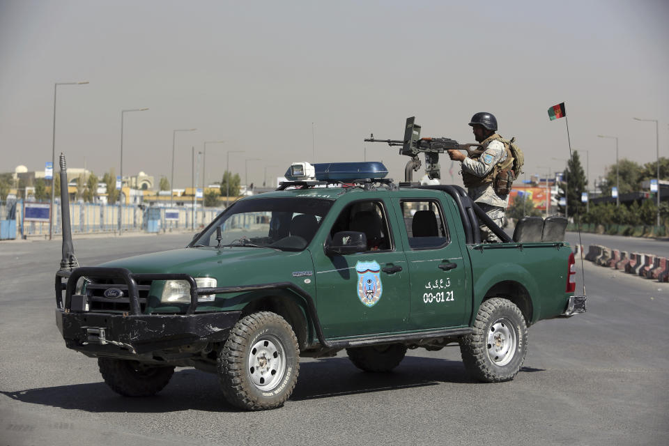 An Afghan security officer mans with a gun near a house where attackers are hiding, in Kabul, Afghanistan, Tuesday, Aug. 21, 2018. Afghan police say the Taliban fired rockets toward the presidential palace in Kabul as President Ashraf Ghani was giving his holiday message for the Muslim celebrations of Eid al-Adha. (AP Photo/Rahmat Gul)