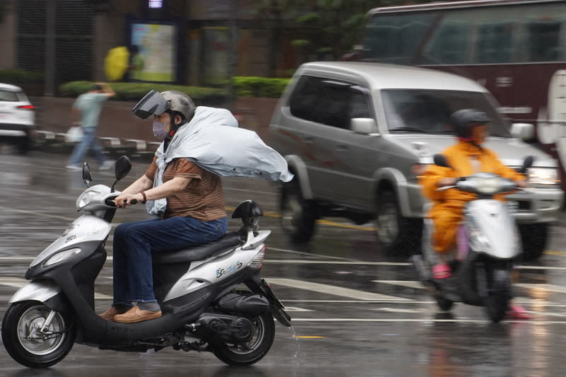 颱風杜蘇芮影響  高雄午後下起小雨（3） 中央氣象局27日表示，颱風杜蘇芮在台灣西南方海 面，持續朝北北西方向前進，預估午後南部風雨增 強。圖為27日午後高雄市苓雅區下起小雨，騎車民眾 的雨衣被瞬間強風吹起。 中央社記者董俊志攝  112年7月27日