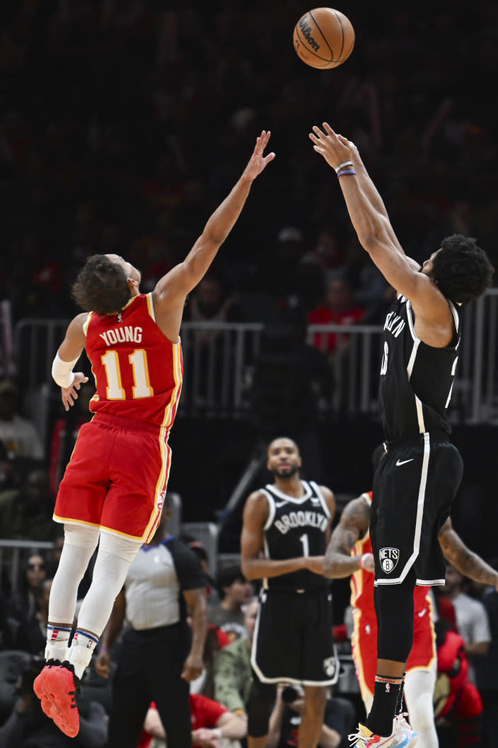 Brooklyn Nets guard Spencer Dinwiddie shoots a 3-pointer against Atlanta Hawks guard Trae Young (11) during the second half of an NBA basketball game Wednesday, Dec. 6, 2023, in Atlanta. (AP Photo/Hakim Wright Sr.)