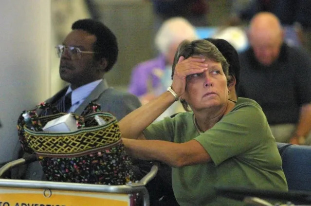 Una viajera varada de United Airlines mirando una pantalla el 11 de septiembre de 2001 en el Aeropuerto Internacional O'Hare de Chicago. Todo el tráfico aéreo en el aeropuerto se cerró después del ataque terrorista contra el World Trade Center en Nueva York.