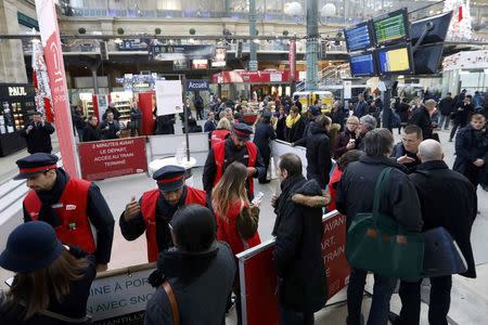 Travellers speak with SNCF employees at the Gare du Nord train station after a power outage that has suspended main line services, including the Eurostar, RER commuter trains and suburban train services at the station in Paris, France, December 7, 2016. REUTERS/Yves Herman