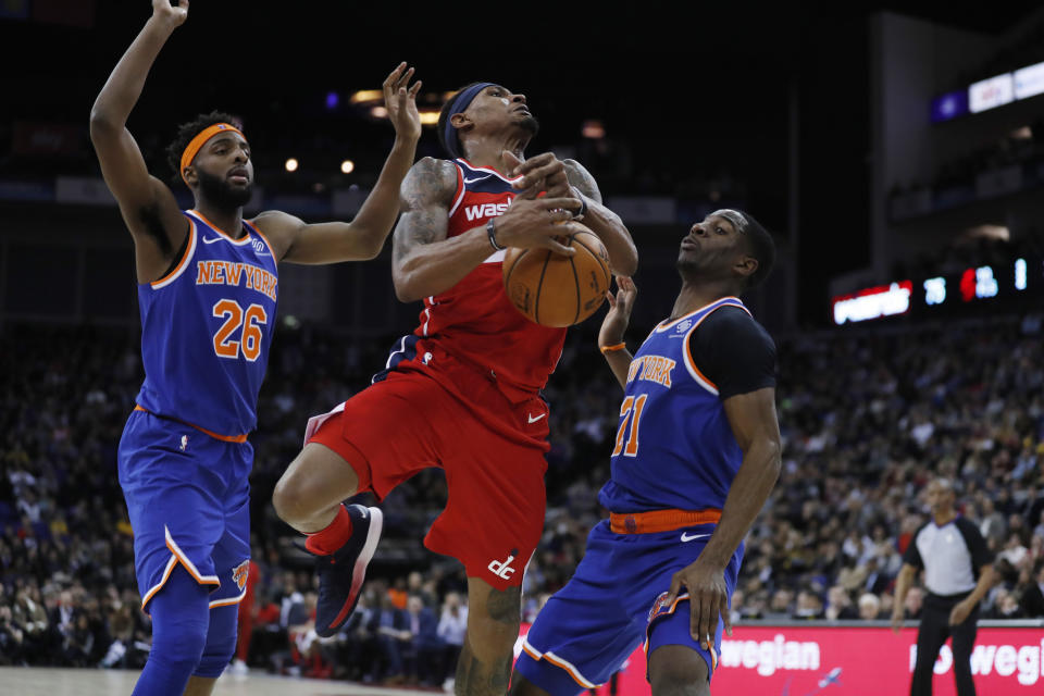 Washington Wizards guard Bradley Beal (3), is drives to the basket flanked by New York Knicks center Mitchell Robinson (26), left, and his teammate guard Damyean Dotson (21), during an NBA basketball game between New York Knicks and Washington Wizards at the O2 Arena, in London, Thursday, Jan.17, 2019. (AP Photo/Alastair Grant)