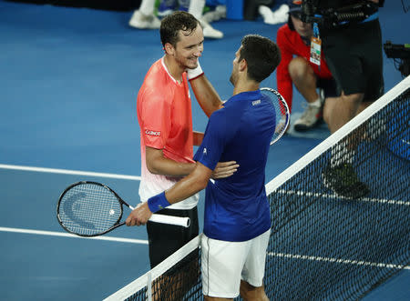 Tennis - Australian Open - Fourth Round - Melbourne Park, Melbourne, Australia, January 22, 2019. Serbia's Novak Djokovic and Russia's Daniil Medvedev hug after the match. REUTERS/Edgar Su