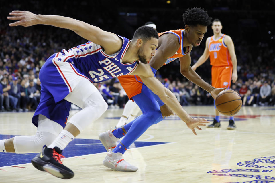 Oklahoma City Thunder's Shai Gilgeous-Alexander, right, and Philadelphia 76ers' Ben Simmons chase down a loose ball during the first half of an NBA basketball game, Monday, Jan. 6, 2020, in Philadelphia. (AP Photo/Matt Slocum)