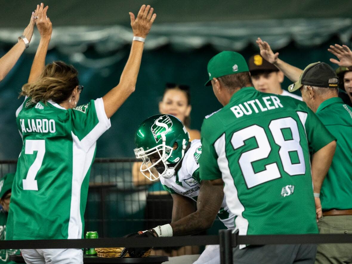 Saskatchewan Roughriders wide receiver D'haquille Williams jumps in with fans after scoring a touchdown on the Edmonton Elks during second half CFL action in Edmonton, Alta., on Aug. 13, 2022. (THE CANADIAN PRESS - image credit)