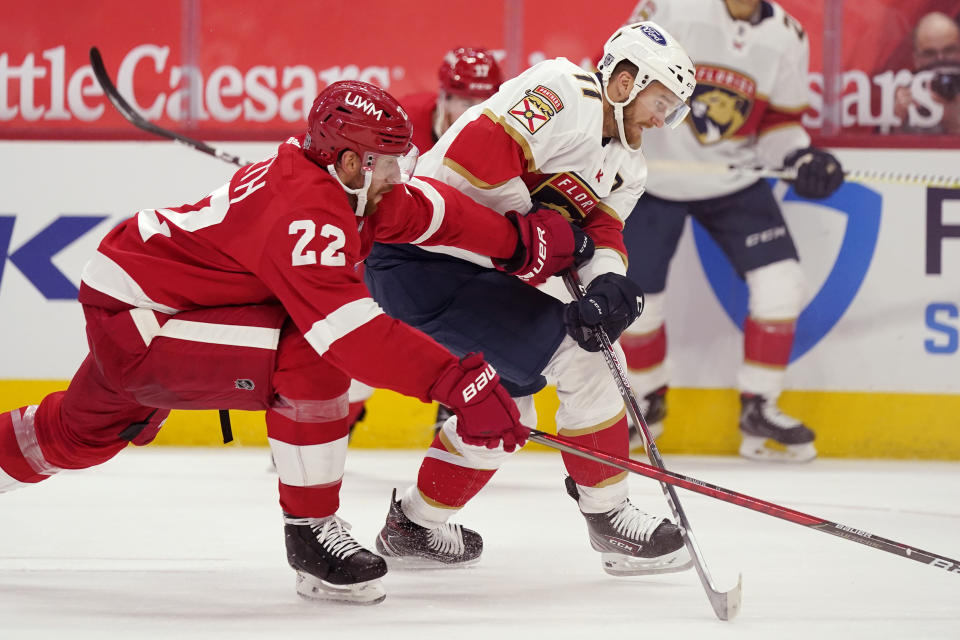 Detroit Red Wings defenseman Patrik Nemeth (22) and Florida Panthers left wing Jonathan Huberdeau (11) chase the puck during the first period of an NHL hockey game, Saturday, Jan. 30, 2021, in Detroit. (AP Photo/Carlos Osorio)