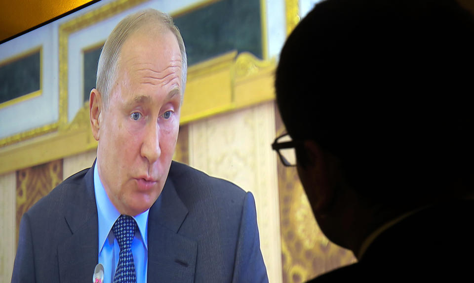 Journalists watch a TV broadcast of a meeting of Russian president Vladimir Putin with heads of news agencies at the St. Petersburg International Economic Forum in St.Petersburg, Russia, Thursday, June 6, 2019. (AP Photo/Dmitri Lovetsky)